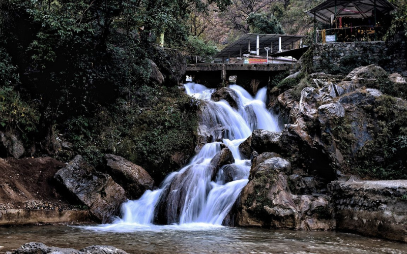 Scenic view of Kempty Falls in Mussoorie with water cascading down rocky cliffs surrounded by lush greenery