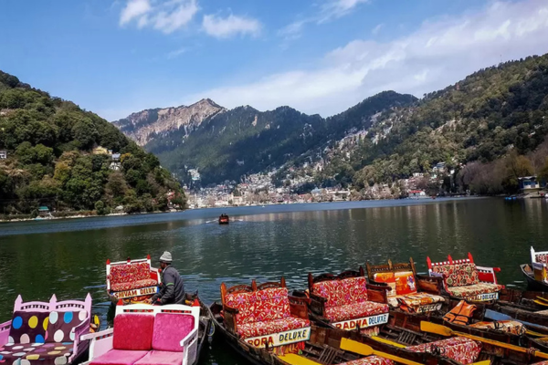 Wide shot of empty Naini Lake with boats resting at the dock.